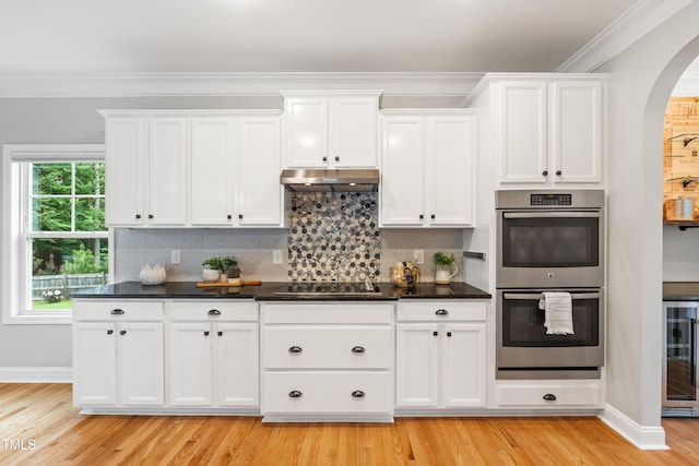 400 Swann Trl, Clayton, NC 27527 - kitchen featuring stainless steel double oven, arched walkways, wine cooler, white cabinetry, and decorative backsplash