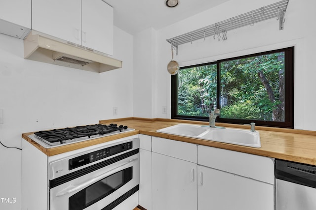 8510 Dunlee Falls Rd, Raleigh, NC 27613 - kitchen with white appliances, wooden counters, white cabinetry, and under cabinet range hood