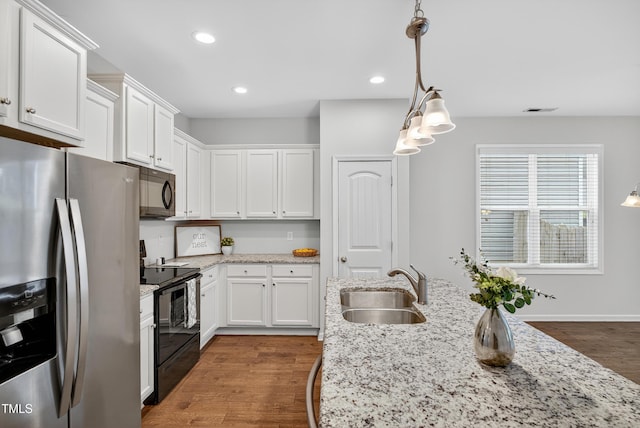 159 Forsyth Pkwy, Clayton, NC 27520 - kitchen with black appliances, white cabinets, hanging light fixtures, light stone counters, and recessed lighting