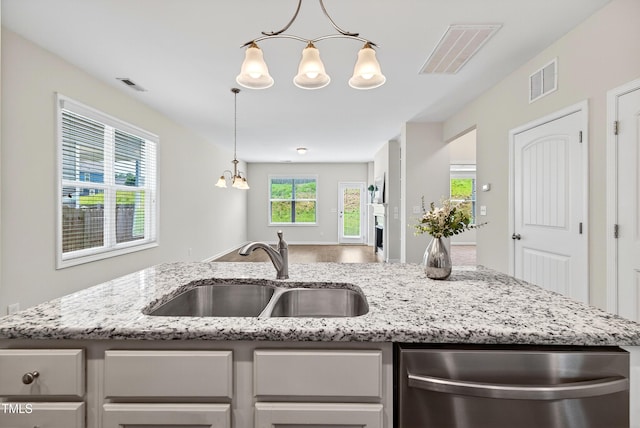 159 Forsyth Pkwy, Clayton, NC 27520 - kitchen with dishwasher, a chandelier, light stone counters, wood finished floors, and pendant lighting