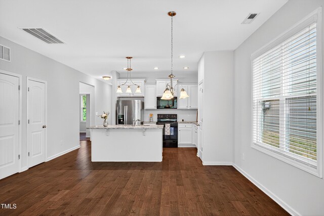 159 Forsyth Pkwy, Clayton, NC 27520 - kitchen with black appliances, an island with sink, dark wood-type flooring, a breakfast bar area, and light stone countertops