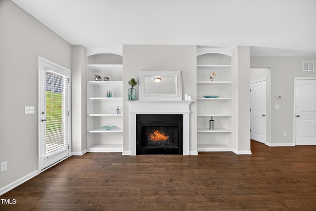 159 Forsyth Pkwy, Clayton, NC 27520 - unfurnished living room featuring built in shelves, wood finished floors, and a warm lit fireplace