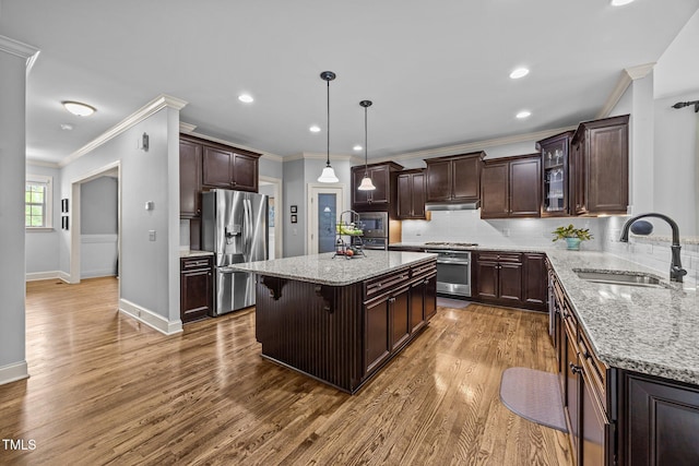 3036 Lawson Walk Way, Rolesville, NC 27571 - kitchen with appliances with stainless steel finishes, under cabinet range hood, crown molding, light stone countertops, and dark brown cabinetry