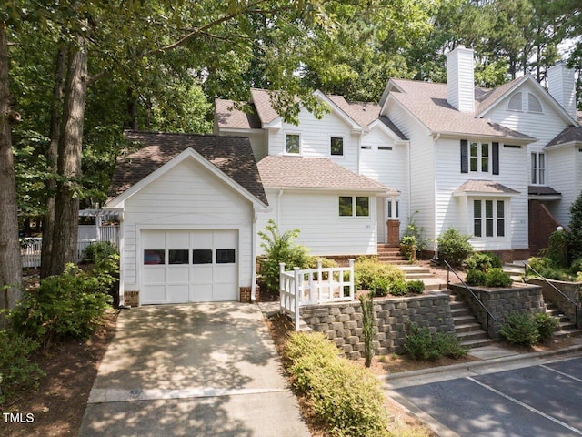 3811 Carnegie Ln, Raleigh, NC 27612 - view of front of house featuring stairs, driveway, a shingled roof, and an attached garage