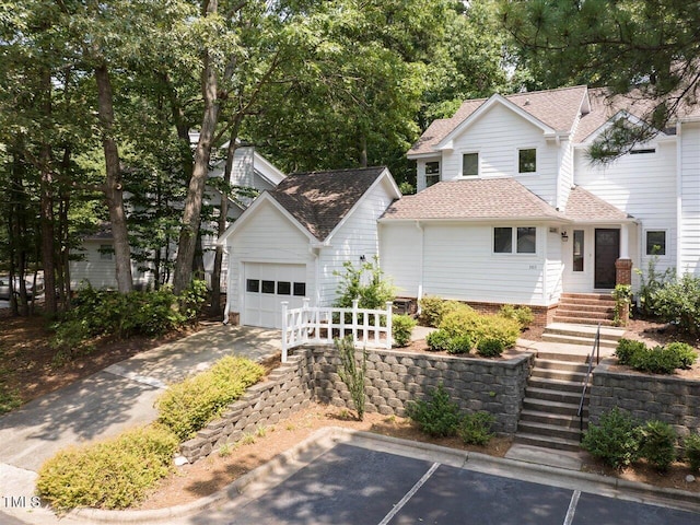 3811 Carnegie Ln, Raleigh, NC 27612 - traditional home featuring a shingled roof, an outbuilding, an attached garage, uncovered parking, and stairway