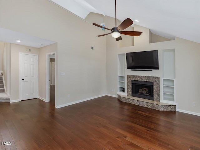 3811 Carnegie Ln, Raleigh, NC 27612 - unfurnished living room featuring a ceiling fan, wood finished floors, high vaulted ceiling, stairway, and a tiled fireplace