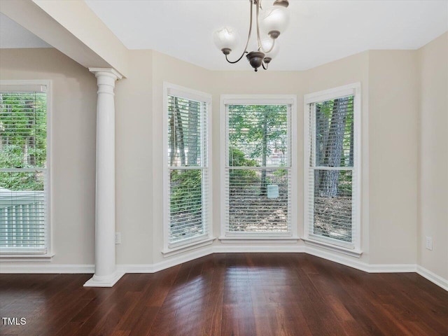 3811 Carnegie Ln, Raleigh, NC 27612 - unfurnished dining area featuring wood finished floors, plenty of natural light, a chandelier, and ornate columns