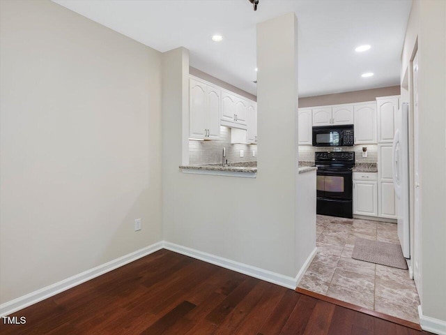 3811 Carnegie Ln, Raleigh, NC 27612 - kitchen with black appliances, wood finished floors, white cabinets, tasteful backsplash, and recessed lighting