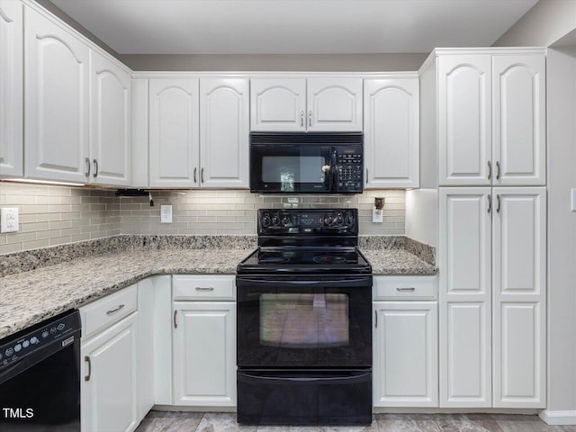 3811 Carnegie Ln, Raleigh, NC 27612 - kitchen with black appliances, white cabinetry, light stone counters, and decorative backsplash