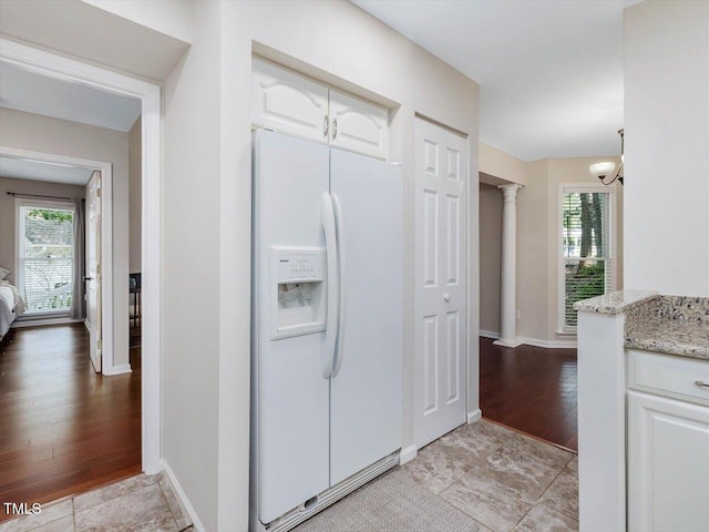 3811 Carnegie Ln, Raleigh, NC 27612 - kitchen with white fridge with ice dispenser, white cabinets, a chandelier, light stone countertops, and light wood-style floors
