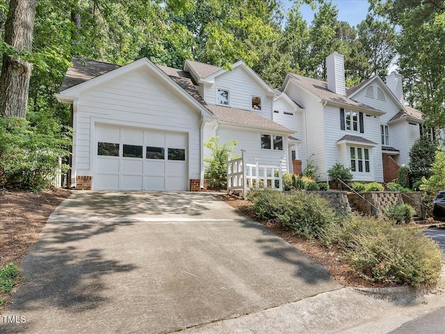 3811 Carnegie Ln, Raleigh, NC 27612 - view of front of property featuring a garage, driveway, brick siding, and roof with shingles