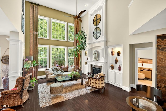 1806 Pattersons Mill Rd, Durham, NC 27703 - living area featuring a towering ceiling, a ceiling fan, a fireplace, and dark wood-style flooring