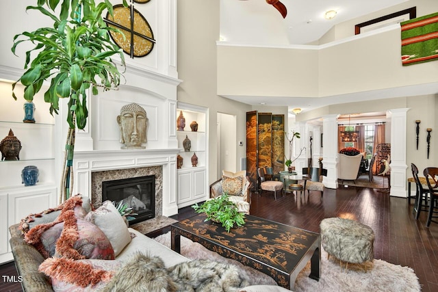 1806 Pattersons Mill Rd, Durham, NC 27703 - living area with decorative columns, wood-type flooring, a premium fireplace, and a towering ceiling