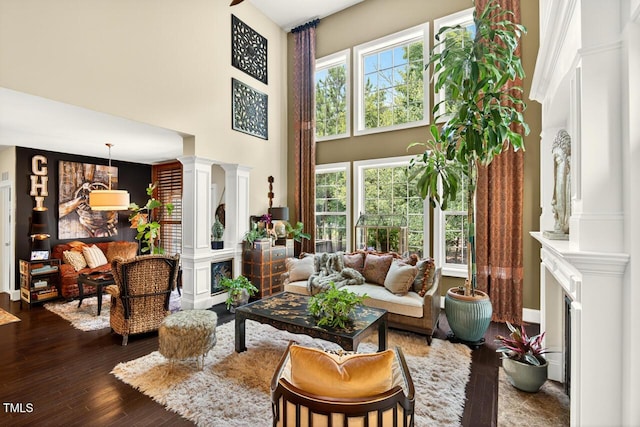 1806 Pattersons Mill Rd, Durham, NC 27703 - living area featuring a fireplace, a high ceiling, ornate columns, and dark wood-type flooring