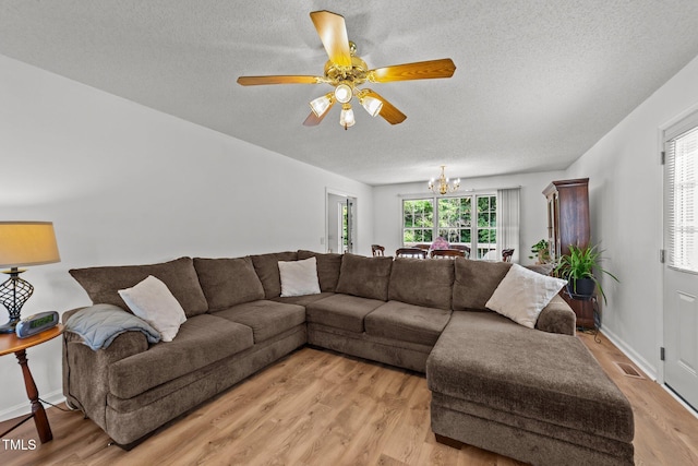 918 Circle Dr, Angier, NC 27501 - living room with a textured ceiling, a chandelier, light wood-style flooring, and ceiling fan