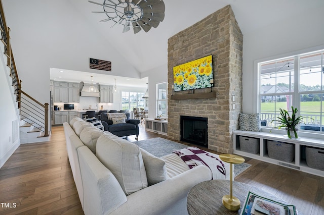 447 Marcellus Way, Clayton, NC 27527 - living room featuring high vaulted ceiling, wood finished floors, stairway, a fireplace, and ceiling fan
