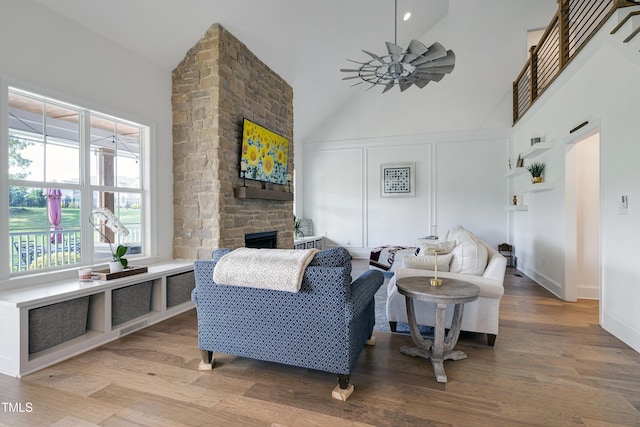 447 Marcellus Way, Clayton, NC 27527 - living room featuring high vaulted ceiling, a stone fireplace, wood finished floors, and ceiling fan