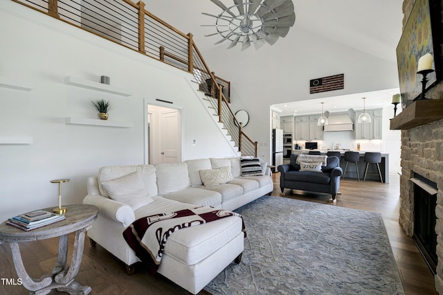 447 Marcellus Way, Clayton, NC 27527 - living room featuring stairway, dark wood finished floors, a stone fireplace, and high vaulted ceiling