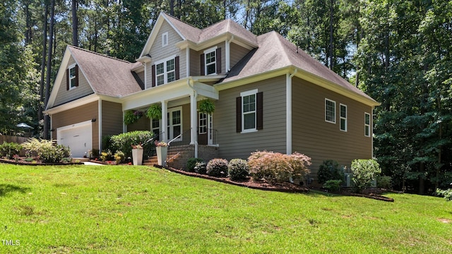 149 Hadley Ln, Clayton, NC 27527 - craftsman-style home with covered porch, a front yard, roof with shingles, and a garage