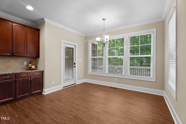 149 Hadley Ln, Clayton, NC 27527 - unfurnished dining area with dark wood-style flooring, healthy amount of natural light, crown molding, and a chandelier