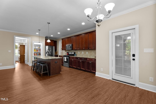 149 Hadley Ln, Clayton, NC 27527 - kitchen with appliances with stainless steel finishes, crown molding, dark wood finished floors, a breakfast bar area, and backsplash