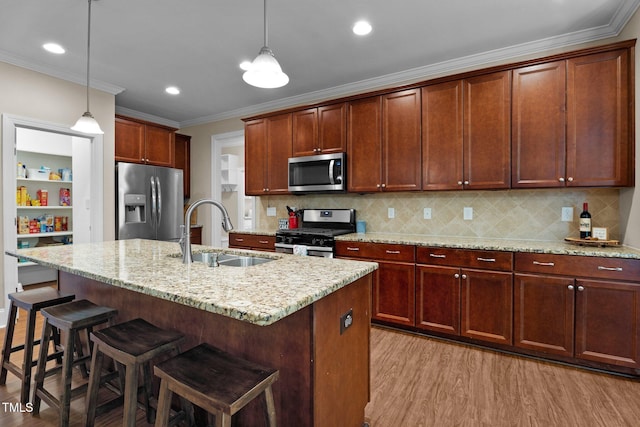 149 Hadley Ln, Clayton, NC 27527 - kitchen featuring appliances with stainless steel finishes, light wood-style floors, pendant lighting, light stone countertops, and a breakfast bar area