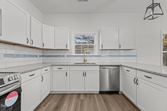 112 Edgewood Dr, Roxboro, NC 27573 - kitchen with appliances with stainless steel finishes, white cabinets, wood finished floors, and tasteful backsplash