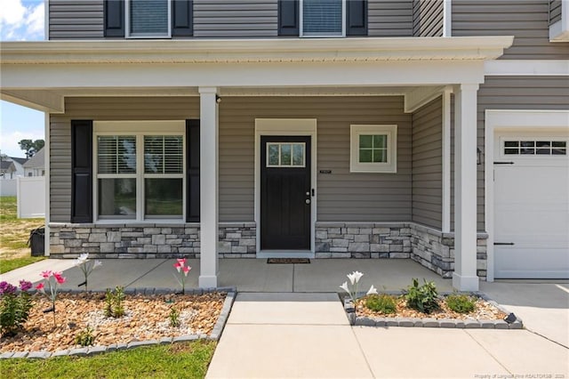 283 Leach Creek Dr, Raeford, NC 28376 - view of exterior entry with covered porch, stone siding, and a garage