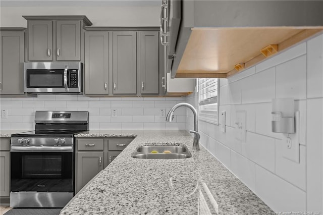 283 Leach Creek Dr, Raeford, NC 28376 - kitchen featuring stainless steel appliances, gray cabinets, decorative backsplash, and light stone counters