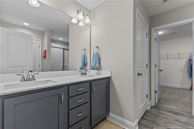 283 Leach Creek Dr, Raeford, NC 28376 - full bathroom featuring double vanity, a spacious closet, a shower with door, recessed lighting, and wood finished floors