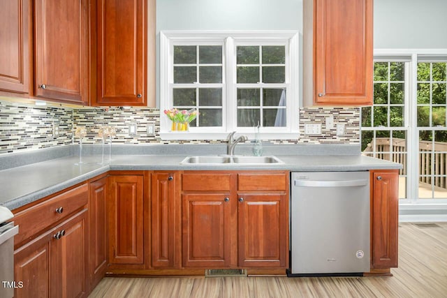 515 Wellingham Dr, Durham, NC 27713 - kitchen featuring stainless steel dishwasher, tasteful backsplash, light countertops, and light wood-style flooring