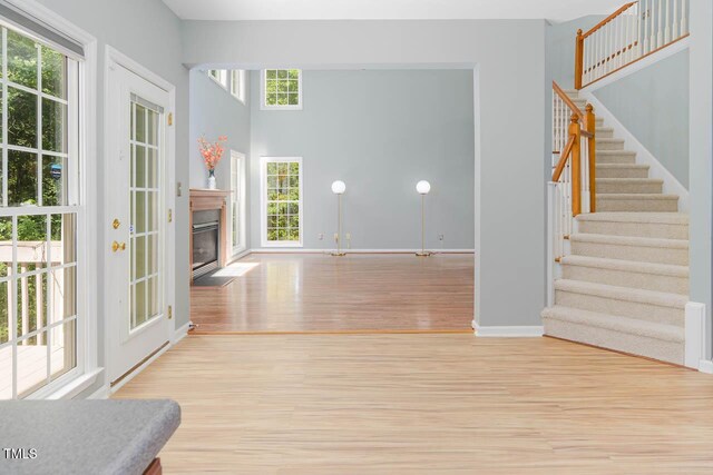 515 Wellingham Dr, Durham, NC 27713 - unfurnished living room with wood finished floors, stairs, and a fireplace with flush hearth
