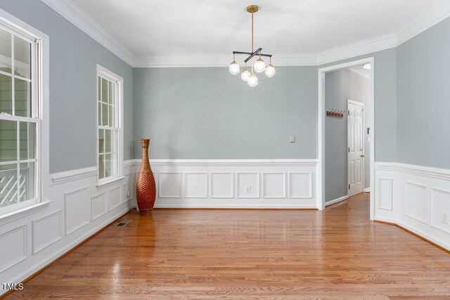 515 Wellingham Dr, Durham, NC 27713 - unfurnished room featuring a chandelier, light wood finished floors, wainscoting, and ornamental molding