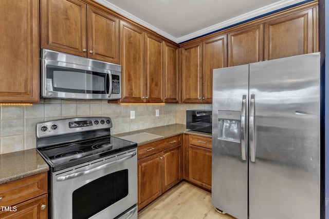 9216 Wooden Rd, Raleigh, NC 27617 - kitchen with stainless steel appliances, brown cabinets, tasteful backsplash, and dark stone counters