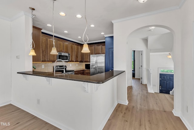 9216 Wooden Rd, Raleigh, NC 27617 - kitchen with stainless steel appliances, arched walkways, recessed lighting, a breakfast bar, and backsplash