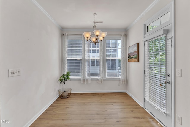 9216 Wooden Rd, Raleigh, NC 27617 - unfurnished dining area featuring a chandelier, ornamental molding, and wood finished floors