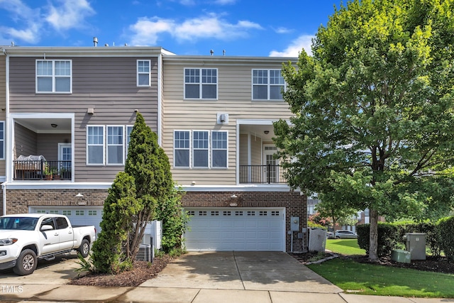 9216 Wooden Rd, Raleigh, NC 27617 - townhome / multi-family property featuring a garage, concrete driveway, and brick siding