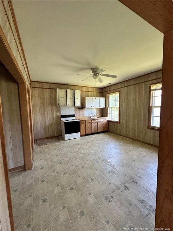 410 W K St, Erwin, NC 28339 - kitchen featuring electric range, light wood finished floors, a ceiling fan, wood walls, and light countertops