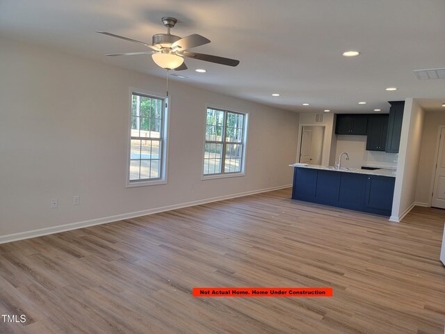 307 E Holmes St, Benson, NC 27504 - unfurnished living room featuring a ceiling fan, light wood finished floors, and recessed lighting