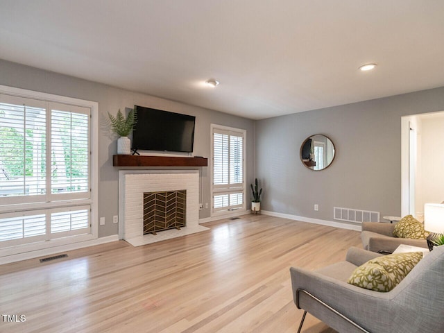 3205 Dell Dr, Raleigh, NC 27609 - living room featuring wood finished floors, a fireplace, and recessed lighting