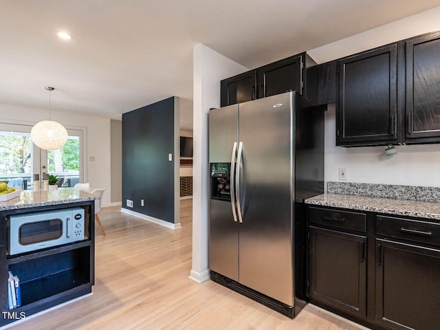 3205 Dell Dr, Raleigh, NC 27609 - kitchen with stainless steel appliances, dark cabinets, light wood-style floors, light stone countertops, and recessed lighting