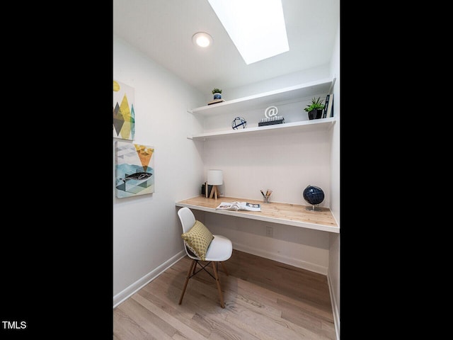 3205 Dell Dr, Raleigh, NC 27609 - home office featuring built in desk, a skylight, light wood-type flooring, and recessed lighting