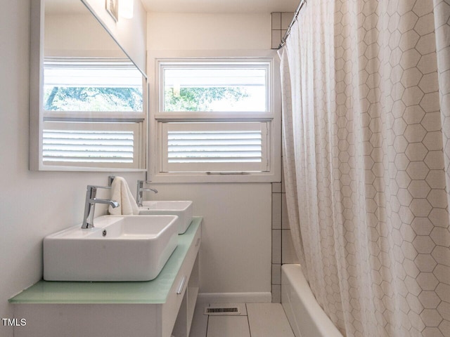 3205 Dell Dr, Raleigh, NC 27609 - full bathroom featuring shower / bathtub combination with curtain, double vanity, and tile patterned flooring