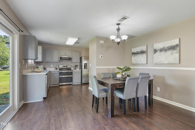 211 Cloverdale Dr, Durham, NC 27703 - dining area featuring a chandelier, dark wood-style flooring, and a textured ceiling