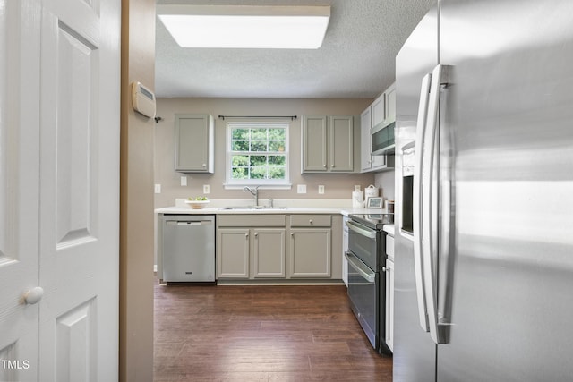 211 Cloverdale Dr, Durham, NC 27703 - kitchen featuring stainless steel appliances, gray cabinets, dark wood-style flooring, light countertops, and a textured ceiling