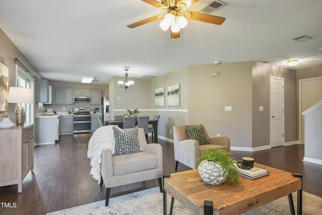211 Cloverdale Dr, Durham, NC 27703 - living room with a chandelier, a ceiling fan, dark wood-style flooring, and a textured ceiling