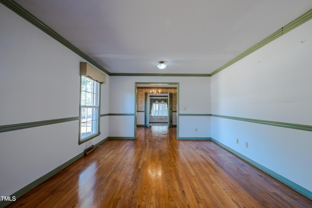 3129 Barwell Rd, Raleigh, NC 27610 - spare room with a chandelier, wood finished floors, and ornamental molding