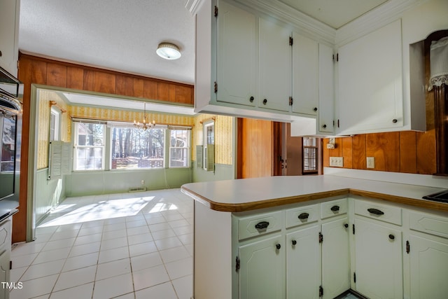 3129 Barwell Rd, Raleigh, NC 27610 - kitchen featuring a chandelier, light tile patterned floors, light countertops, ornamental molding, and wooden walls