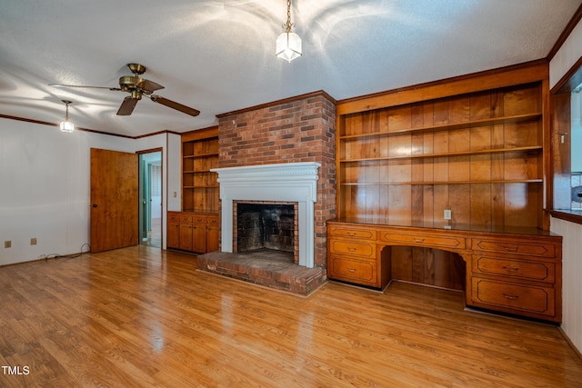3129 Barwell Rd, Raleigh, NC 27610 - unfurnished living room featuring ceiling fan, a brick fireplace, light wood-style floors, a textured ceiling, and built in features