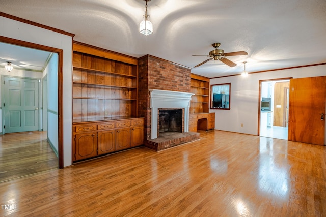3129 Barwell Rd, Raleigh, NC 27610 - unfurnished living room featuring crown molding, a ceiling fan, built in features, light wood-style floors, and a brick fireplace